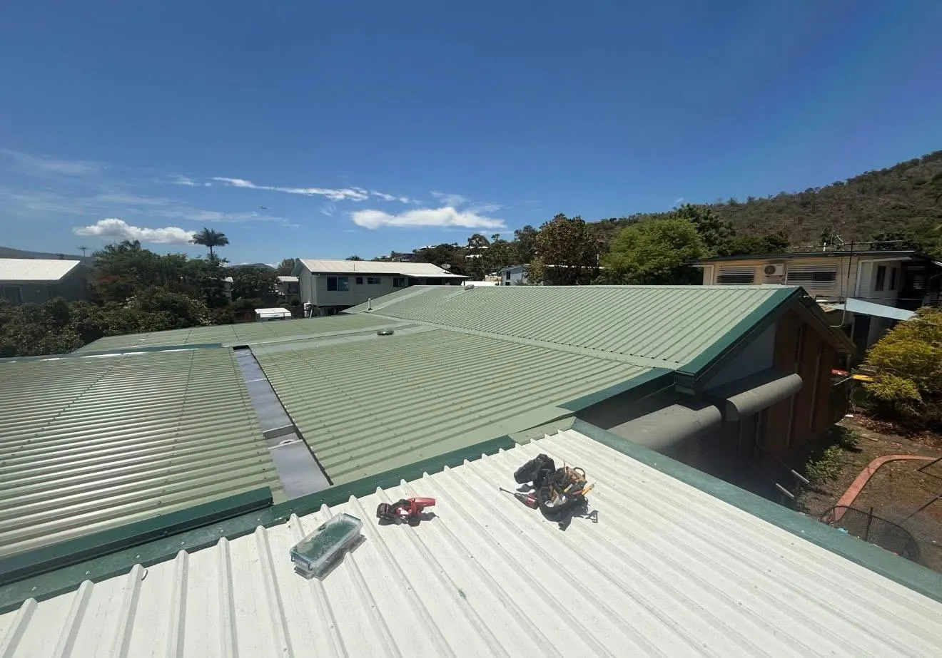 Roof maintenance work on a green metal roof