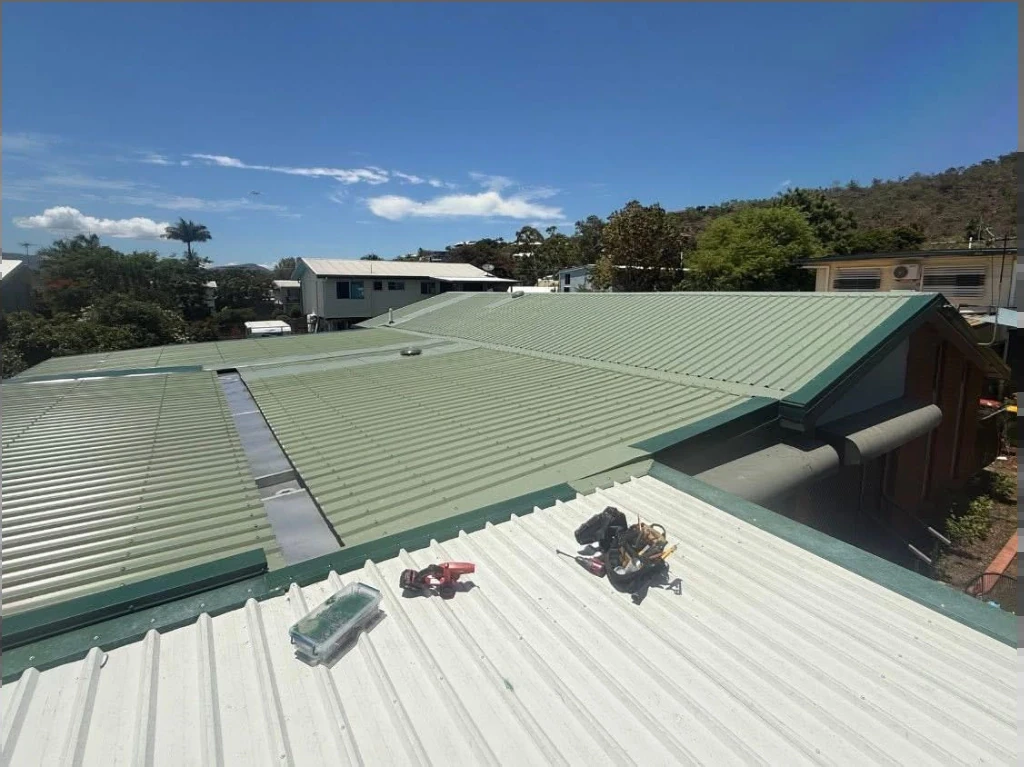 Roof maintenance work on a green metal roof